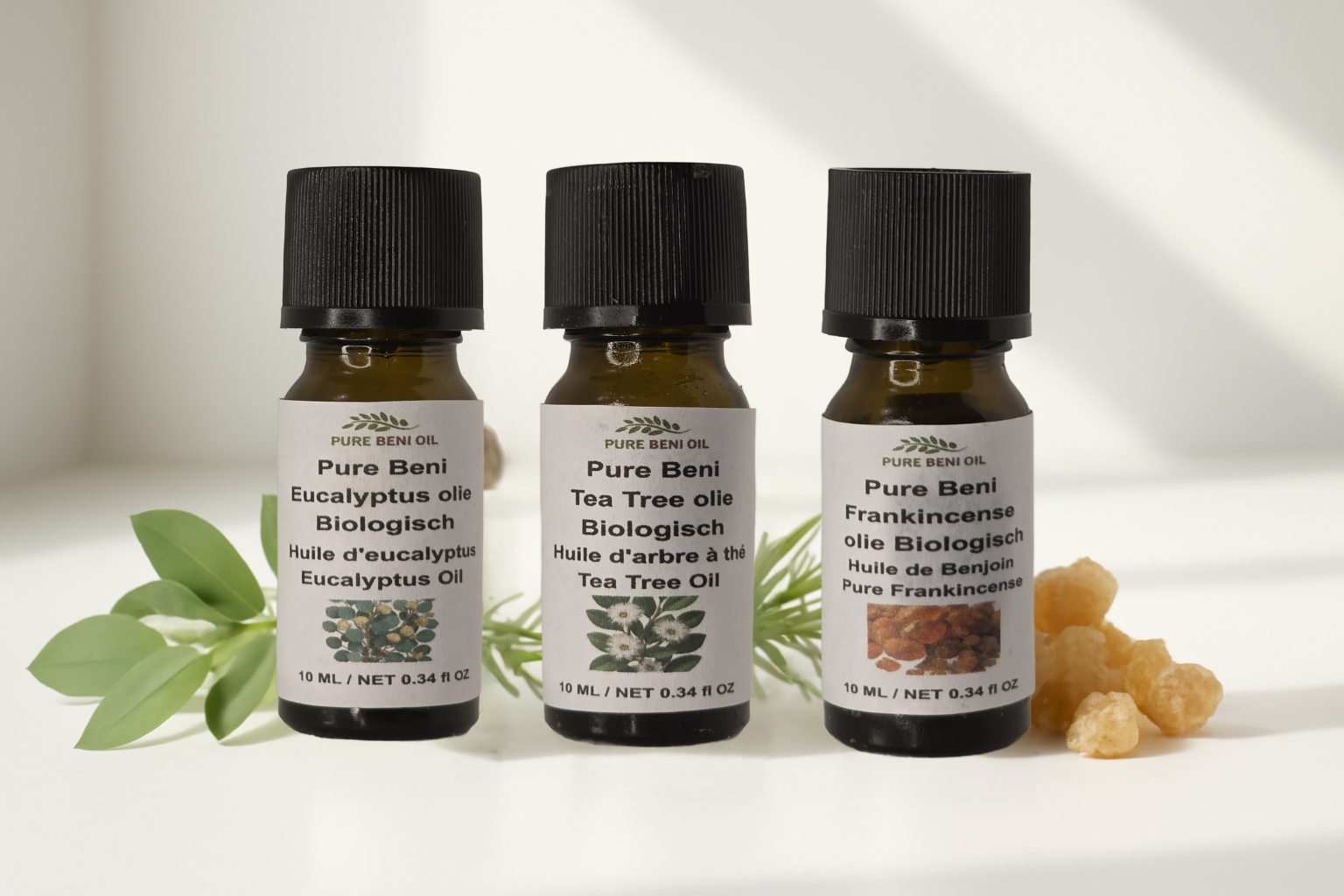 alt=PURE BENI organic essential oils eucalyptus, tea tree and frankincense in amber bottles for wellness rituals